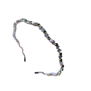 Elegant wavy crystal headband featuring green and clear stones on a slim metal frame
