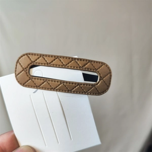 Close-up of brown PU leather hair clip with diamond lattice stitching and hand-stitched edges