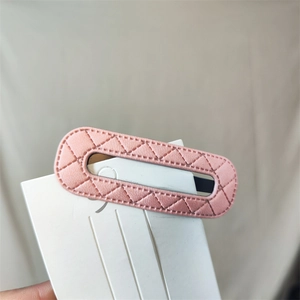 Detailed view of pink quilted PU leather oval hair clip with fine stitching on card