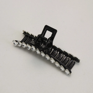 Detailed close-up of a large black shark hair claw clip with crystal heart accents