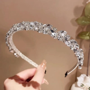 Détail du serre-tête argenté avec de grands cristaux brillants et un travail de fil précis