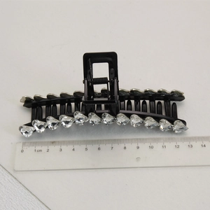 Detail view of a 13cm black claw clip with heart-shaped rhinestones and measuring ruler
