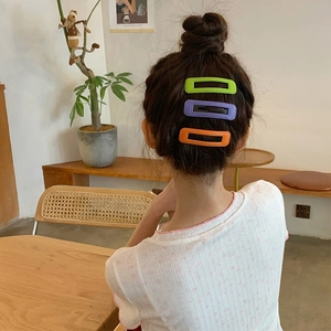 Trois pinces à cheveux rectangulaires en cuir PU coloré portées dans un décor de café