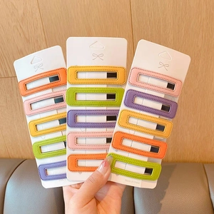 Détail de barrettes BB en simili cuir coloré avec surpiqûres et tons acidulés
