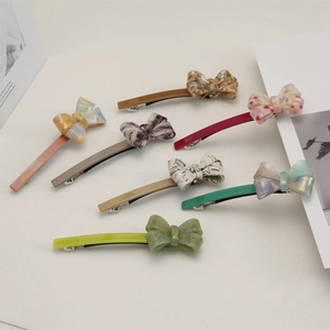 Vue détaillée de sept barrettes à nœuds en acétate avec textures marbrées et dorure à chaud