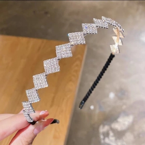 Détail macro du serre-tête argenté avec des motifs géométriques en cristal brillant