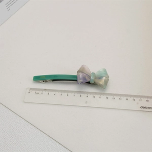 Détail de la barrette nœud en acétate iridescent avec gravure France Handmade et clip métal