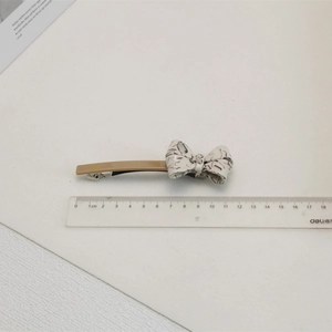 Vue détaillée d'une pince à cheveux de 11 cm avec nœud texturé sur un fond blanc