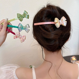 Détail de barrettes nœud en acétate élégantes aux couleurs variées portées sur les cheveux