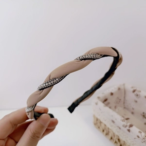Close-up of twisted light brown headband with sparkling silver rhinestone chain detail