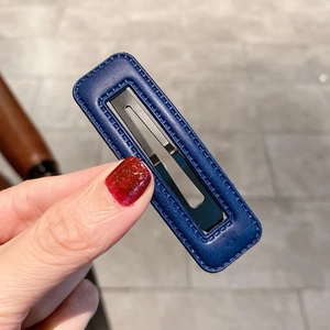 Détail de la barrette rectangulaire en cuir PU bleu foncé avec coutures à la main et clip en métal