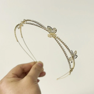 Detail of golden double-layer butterfly headband with shimmering rhinestones