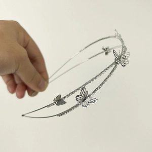 Detailed macro of a silver double-layered headband with hollow butterflies and rhinestones