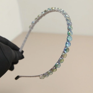 Detailed macro shot of aurora crystal glass beads on a slim elegant silver headband
