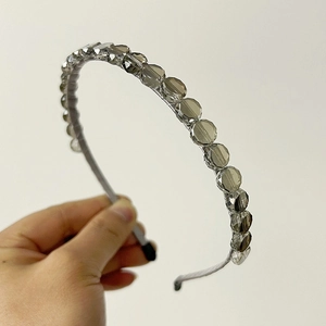 Close-up of thin headband with grey multifaceted crystal beads and satin fabric wrap