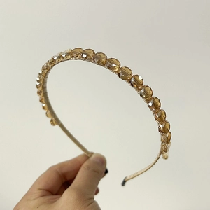 Detailed view of champagne crystal beaded headband with light gold metallic frame