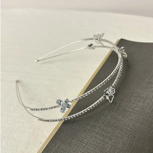 Detail of double-layer silver headband with sparkling rhinestones and butterfly motifs