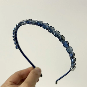 Detail view of navy blue velvet headband decorated with faceted crystal glass beads