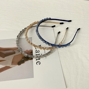 Close-up of three beaded headbands with faceted glass crystals in grey, amber and blue