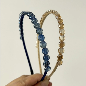 Close-up of handmade beaded headbands featuring faceted blue and champagne crystals