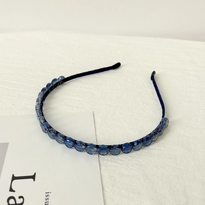 Detail shot of elegant navy blue faceted crystal beads on a slim metal headband