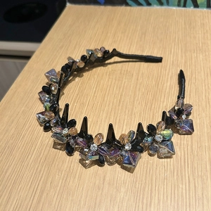 Détail d'un serre-tête de luxe avec fleurs en cristal et peigne sur bois