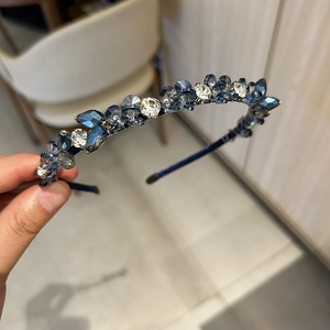 Détail d'un serre-tête vintage orné de cristaux facettés bleu foncé et transparents