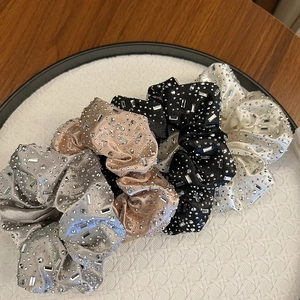 Détail de chouchous en velours de luxe avec strass brillants dans un plateau