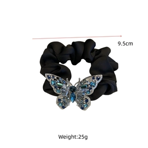 Macro shot of 9.5cm black satin hair scrunchie featuring a crystal butterfly ornament