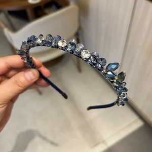 Détail de cristaux bleu foncé et clairs tissés main sur un serre-tête fin