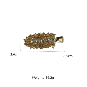 Detailed view of handmade beaded hair clip with amber crystals and gold duckbill base