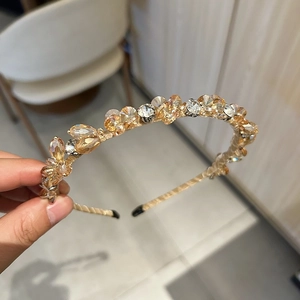 Gros plan du serre-tête en cristal champagne avec strass sur monture dorée fine