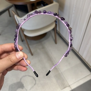 Detail showing hand-held purple headband with amethyst crystal stones and protective tips