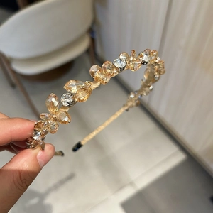 Détail des cristaux ambrés et transparents étincelants sur un serre-tête doré de luxe