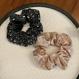 Détails des chouchous en velours noir et champagne avec des strass brillants de luxe