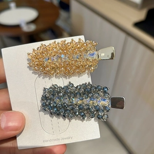 Detailed macro view of handmade beaded hair clips with luxury crystals on display card