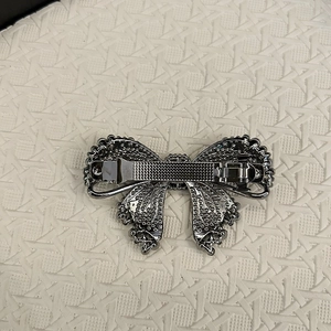 Detailed back view of sparkly bow hair clip with silver crystals and spring fastener