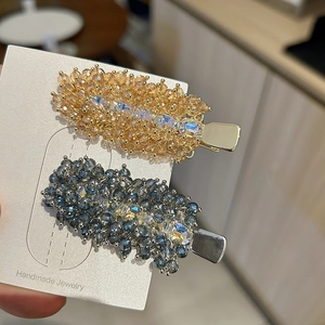 Close-up of handmade luxury hair clips with sparkling crystals and aurora gradient stones