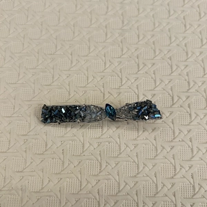 Détail de la pince à cheveux avec cristaux bleus et strass sur support en métal argenté