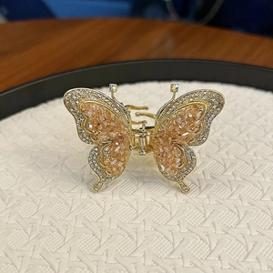 Pince à cheveux papillon dorée avec cristaux champagne et strass blancs étincelants