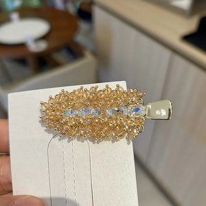 Macro detail of handmade amber crystal hair clip with golden metal base for women