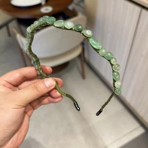 Detailed macro view of the light green gemstone beads on a woven fabric headband