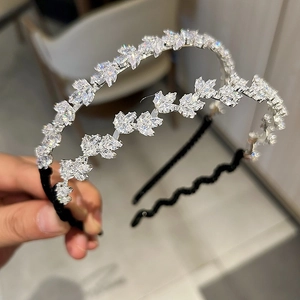 Vue détaillée du serre-tête en cristal argenté et du cerceau à cheveux noir ondulé