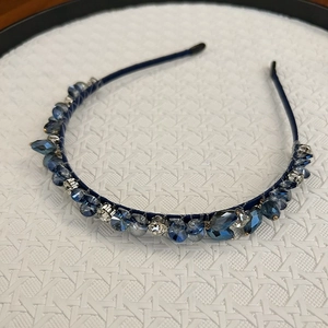 Détail du serre-tête bleu marine orné de cristaux étincelants et de strass de luxe