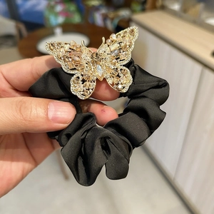 Close-up of black satin scrunchie with crystal butterfly luxury hair accessory