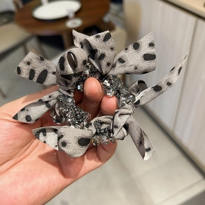 Elegant mesh bow hair clip with black leopard spots and shimmering crystal beads