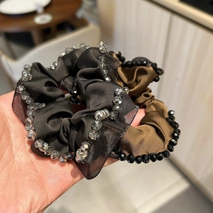 Detail of handmade satin scrunchies with crystal beads in black and deep brown colors
