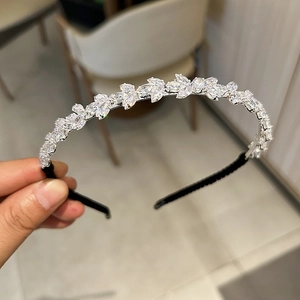 Gros plan détaillé du serre-tête en cristal de zircon avec motif de feuilles argentées
