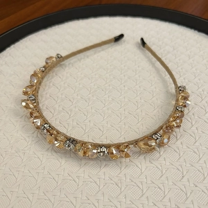 Détail d'un serre-tête fait main avec des cristaux champagne et des perles étincelantes