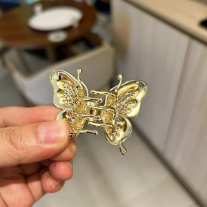 Vue détaillée d'une pince à cheveux papillon dorée avec des motifs métalliques complexes